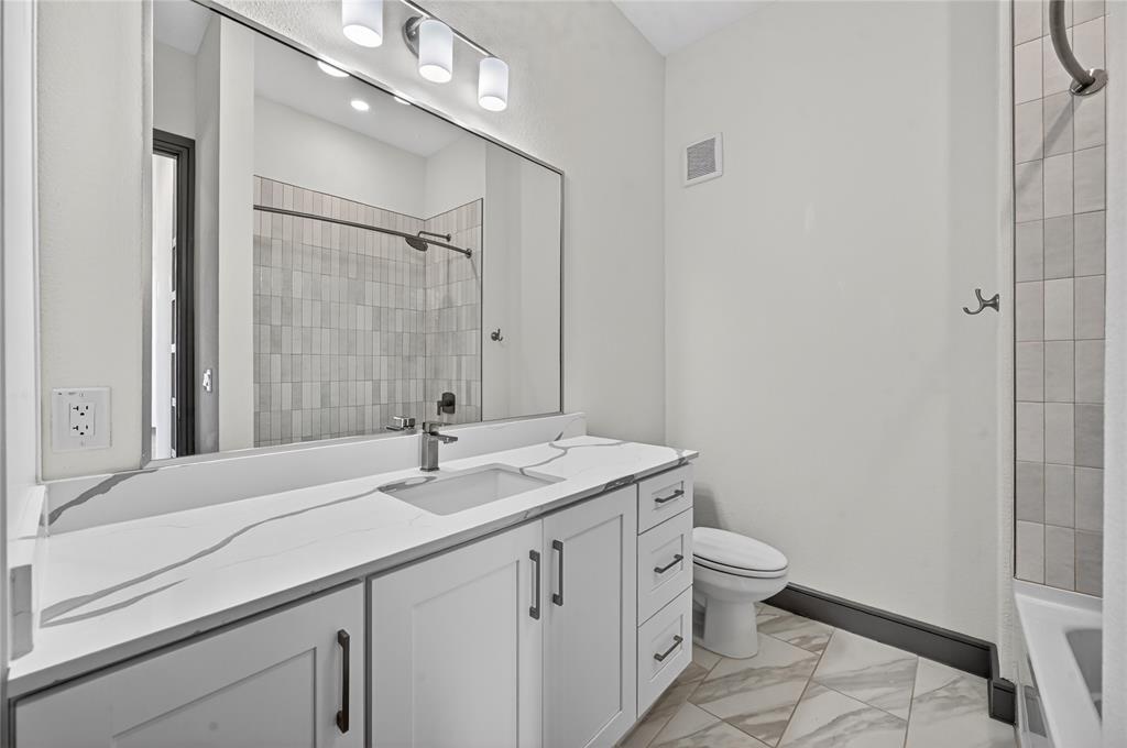 2700 Old Denton Road, Unit 2259 Carrollton, TX 75007 - Photo 28 of 39 a bathroom with a granite countertop sink a toilet and a mirror