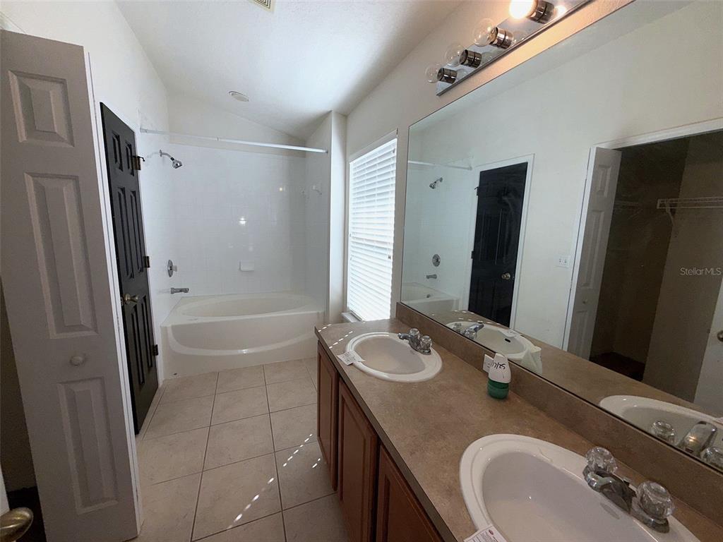5318 Anhinga Trail New Port Richey, FL 34653 - Photo 12 of 17 a bathroom with a granite countertop sink a mirror and a bathtub
