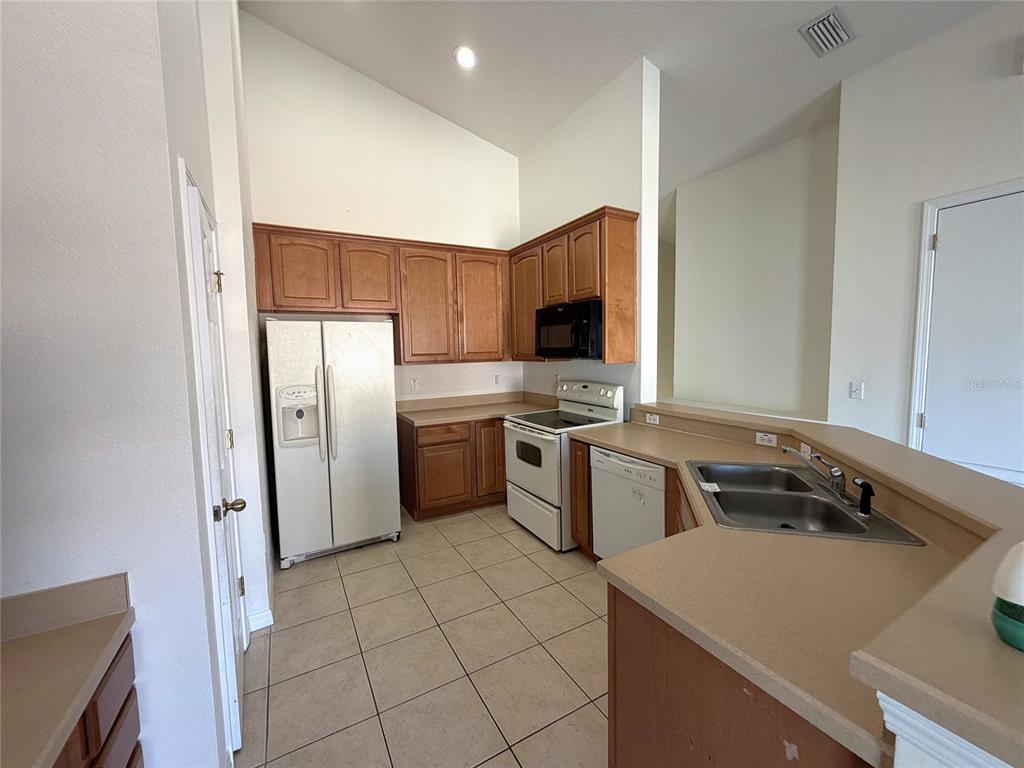 5318 Anhinga Trail New Port Richey, FL 34653 - Photo 5 of 17 a kitchen with a sink a stove and refrigerator