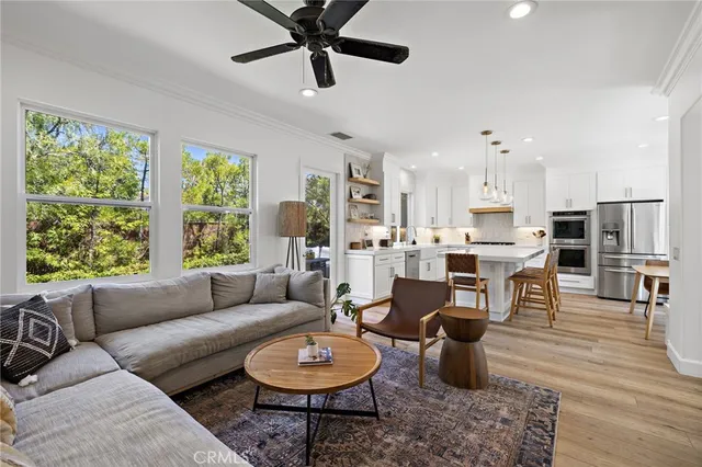 a living room with furniture kitchen view and a large window