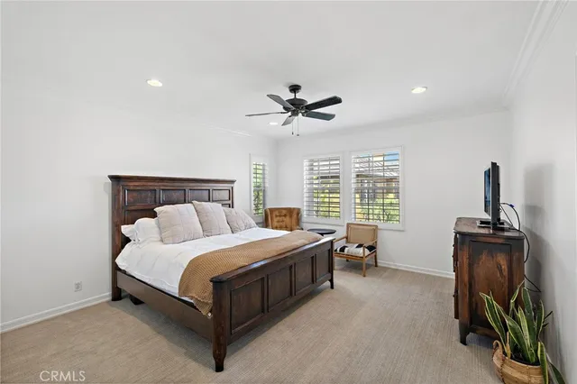 a bedroom with a bed a dresser and a chandelier