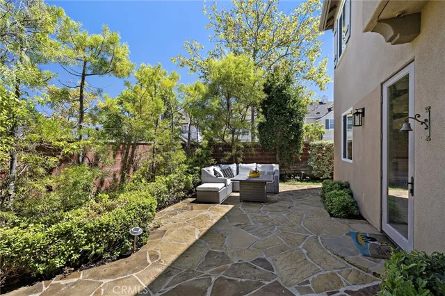 a view of a patio with couches table and chairs and potted plants