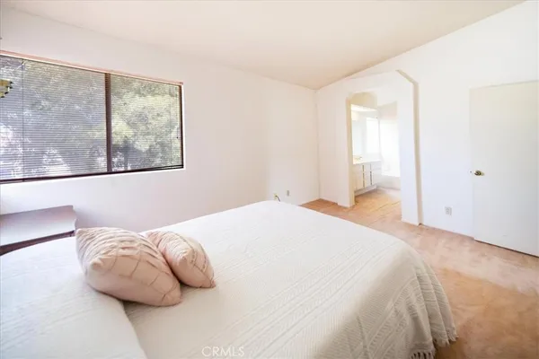 a bedroom with a bed and painting on the wall