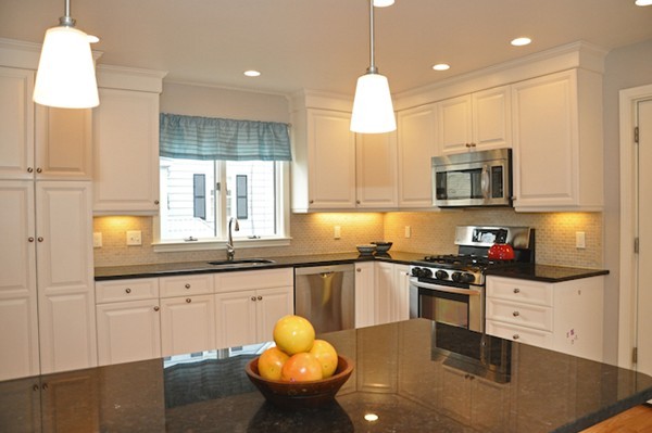 a kitchen with granite countertop a sink a stove and a wooden floor