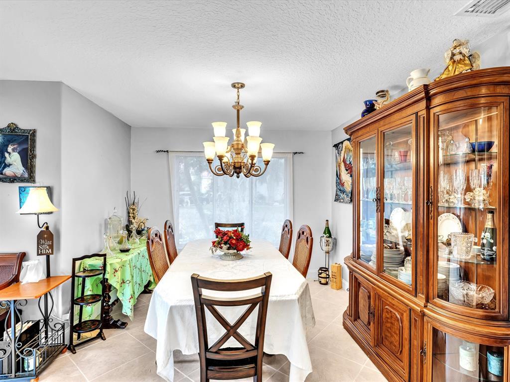 11240 Reveille Road Cooper City, FL 33026 - Photo 17 of 97 a view of a dining room with furniture a chandelier and a window