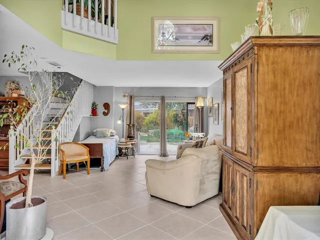 a view of a dining room with furniture a chandelier and a window