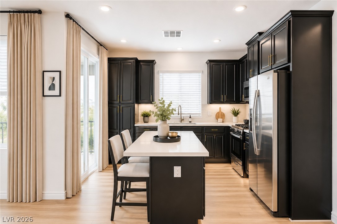 7330 North Decatur Boulevard, Unit 6 North Las Vegas, NV 89084 - Photo 7 of 42 A sleek, contemporary kitchen with dark cabinetry and a central island awaits culinary adventures.
