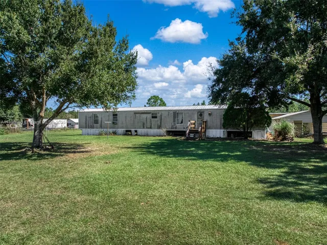 a view of a house with backyard and sitting area