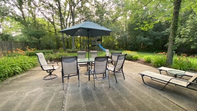 a view of backyard with seating space and trees
