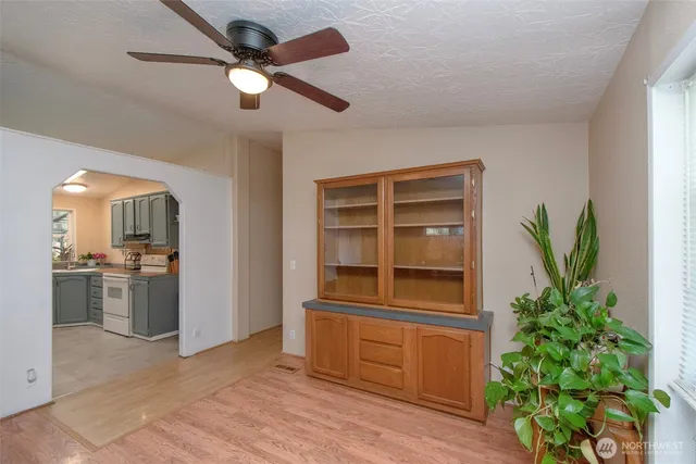 a living room with stainless steel appliances furniture and a potted plant