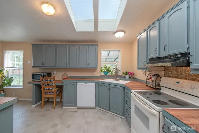 a kitchen with a sink a stove cabinets and a window