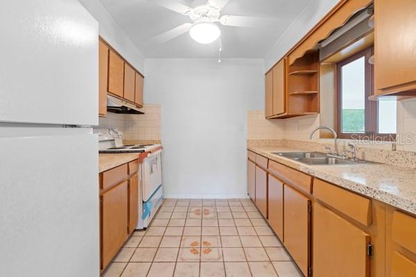 1404 East Alfred Street Tavares, FL 32778 - Photo 23 of 38 a kitchen with granite countertop a sink stove and cabinets