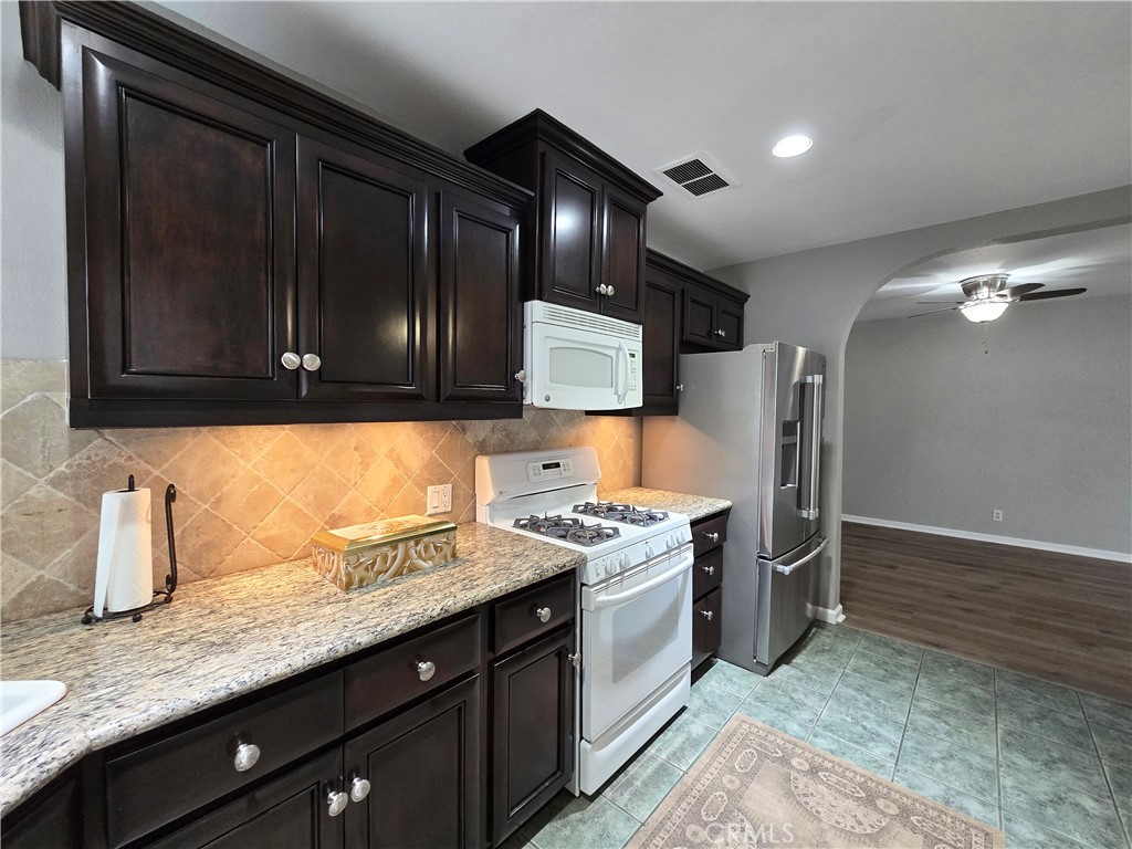 4651 Emerson Street Riverside, CA 92506 - Photo 11 of 32 a kitchen with stainless steel appliances granite countertop a sink stove and refrigerator