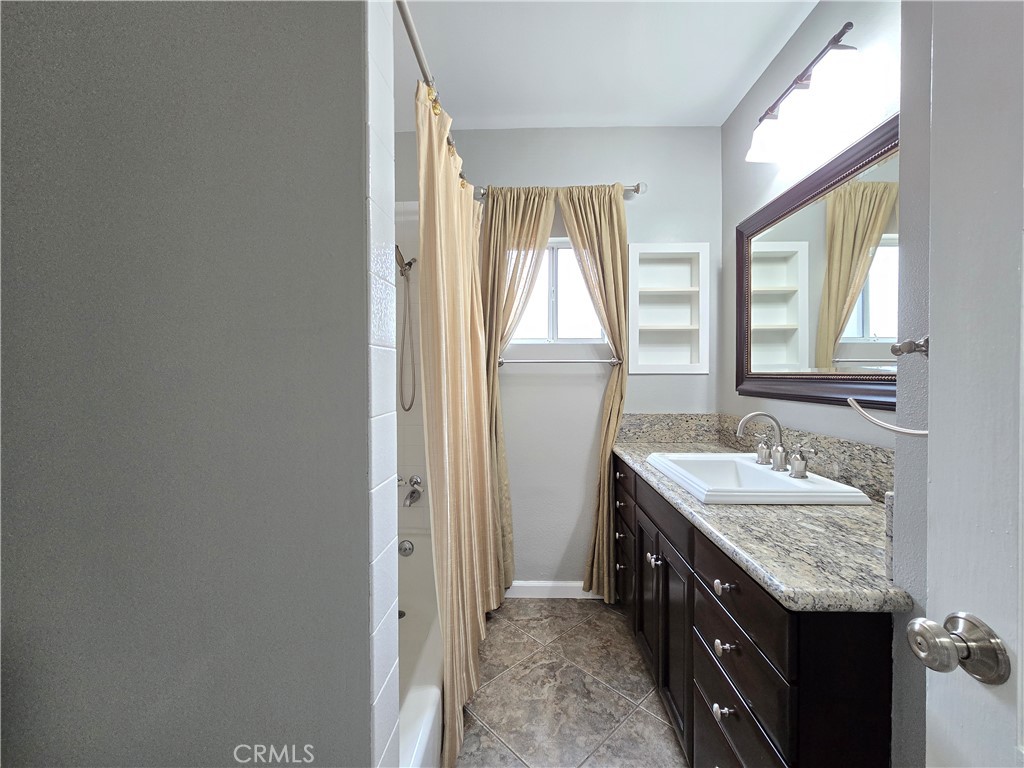 4651 Emerson Street Riverside, CA 92506 - Photo 22 of 32 a spacious bathroom with a granite countertop sink and a mirror