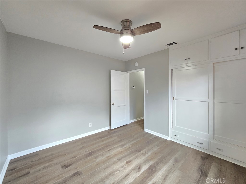 4651 Emerson Street Riverside, CA 92506 - Photo 24 of 32 an empty room with wooden floor and a ceiling fan