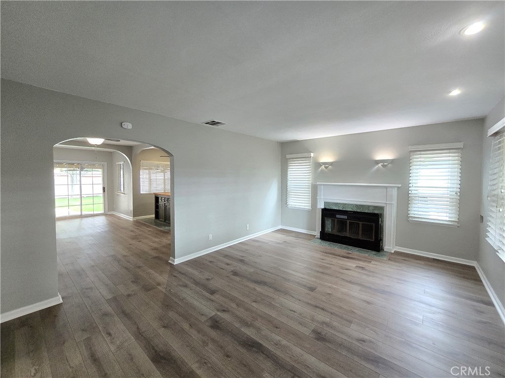 4651 Emerson Street Riverside, CA 92506 - Photo 3 of 32 an empty room with wooden floor fireplace and windows