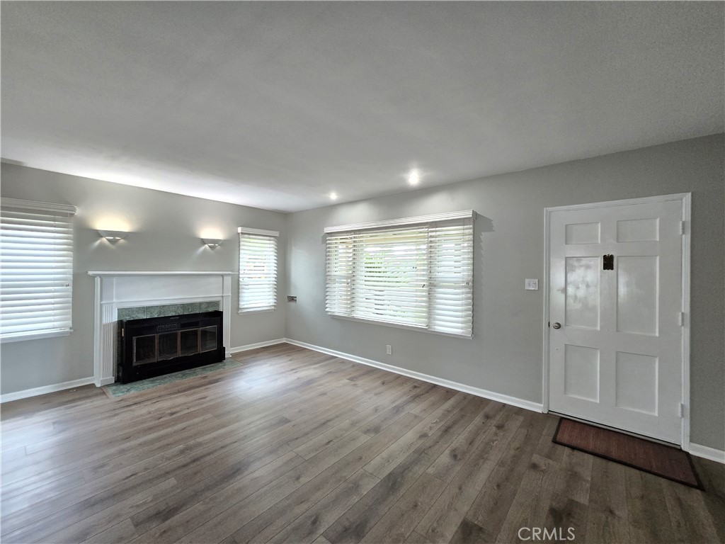 4651 Emerson Street Riverside, CA 92506 - Photo 4 of 32 an empty room with wooden floor fireplace and windows
