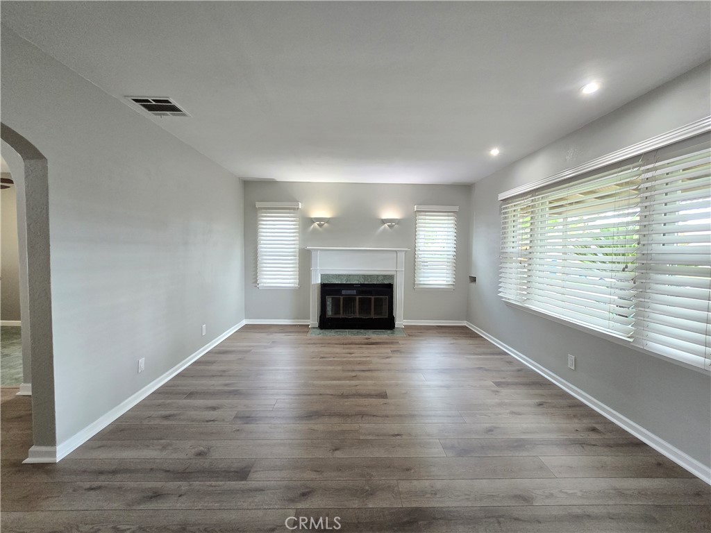 4651 Emerson Street Riverside, CA 92506 - Photo 5 of 32 an empty room with wooden floor fireplace and windows