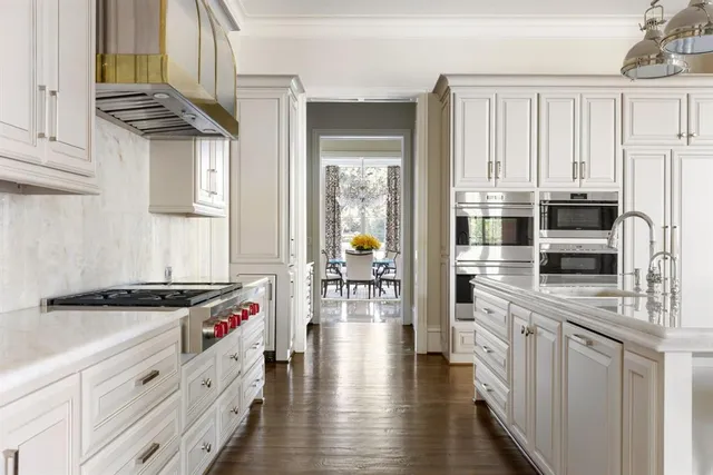 a kitchen with stainless steel appliances granite countertop white cabinets and window