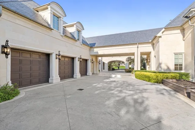 an aerial view of residential house with green space and fog