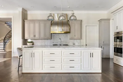 a kitchen with white cabinets and chandelier