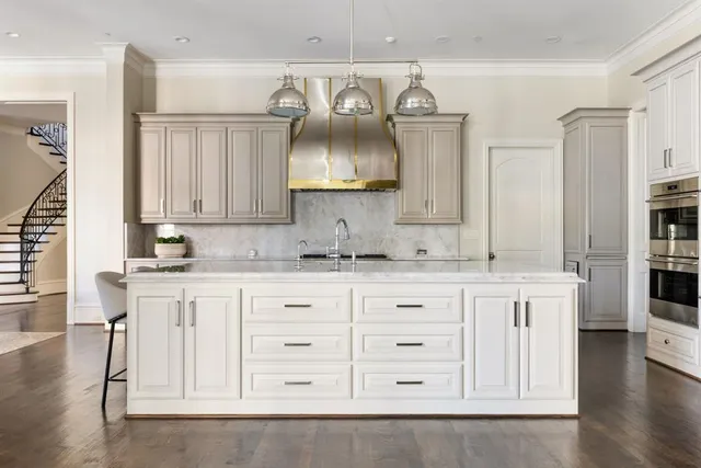 a kitchen with white cabinets and chandelier
