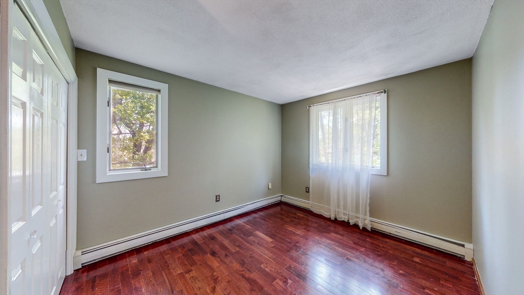 15 Carlin Road Waltham, MA 02451 - Photo 30 of 42 an empty room with wooden floor and windows