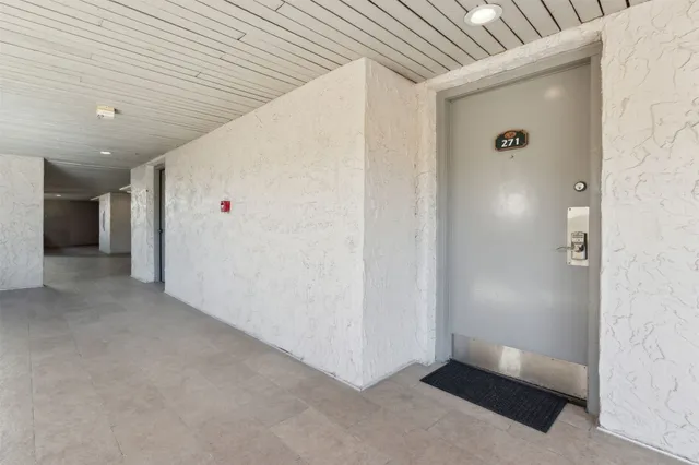 a hallway with a view of living room with wooden floor