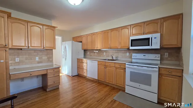 a kitchen with granite countertop wooden cabinets stainless steel appliances and a window