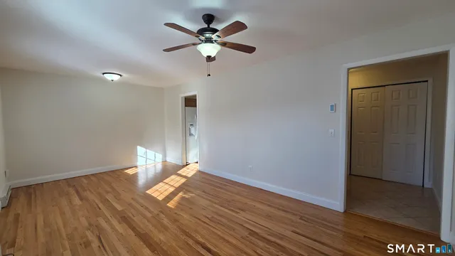 a view of a room with wooden floor and ceiling fan