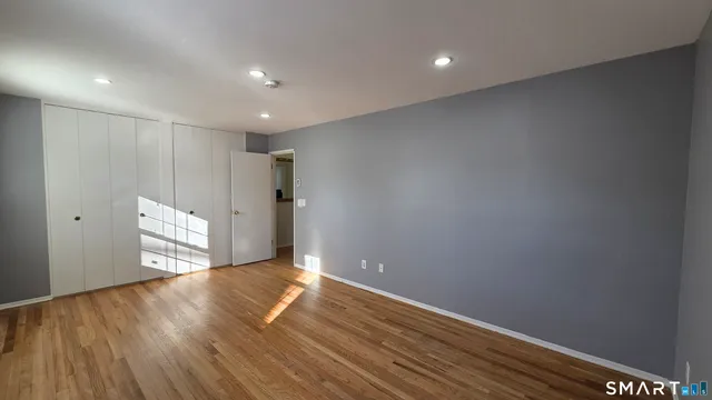a view of empty room with wooden floor