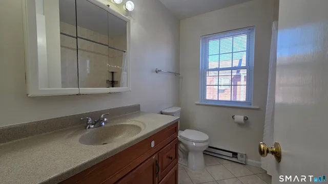 a bathroom with a sink toilet and window