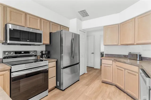 a kitchen with stainless steel appliances a stove sink microwave and cabinets