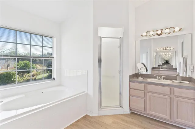 a view of a bedroom with wooden floor and windows