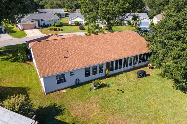 an aerial view of residential houses with outdoor space and trees