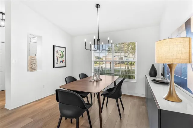 a kitchen with a sink a stove a refrigerator cabinets and a dining table