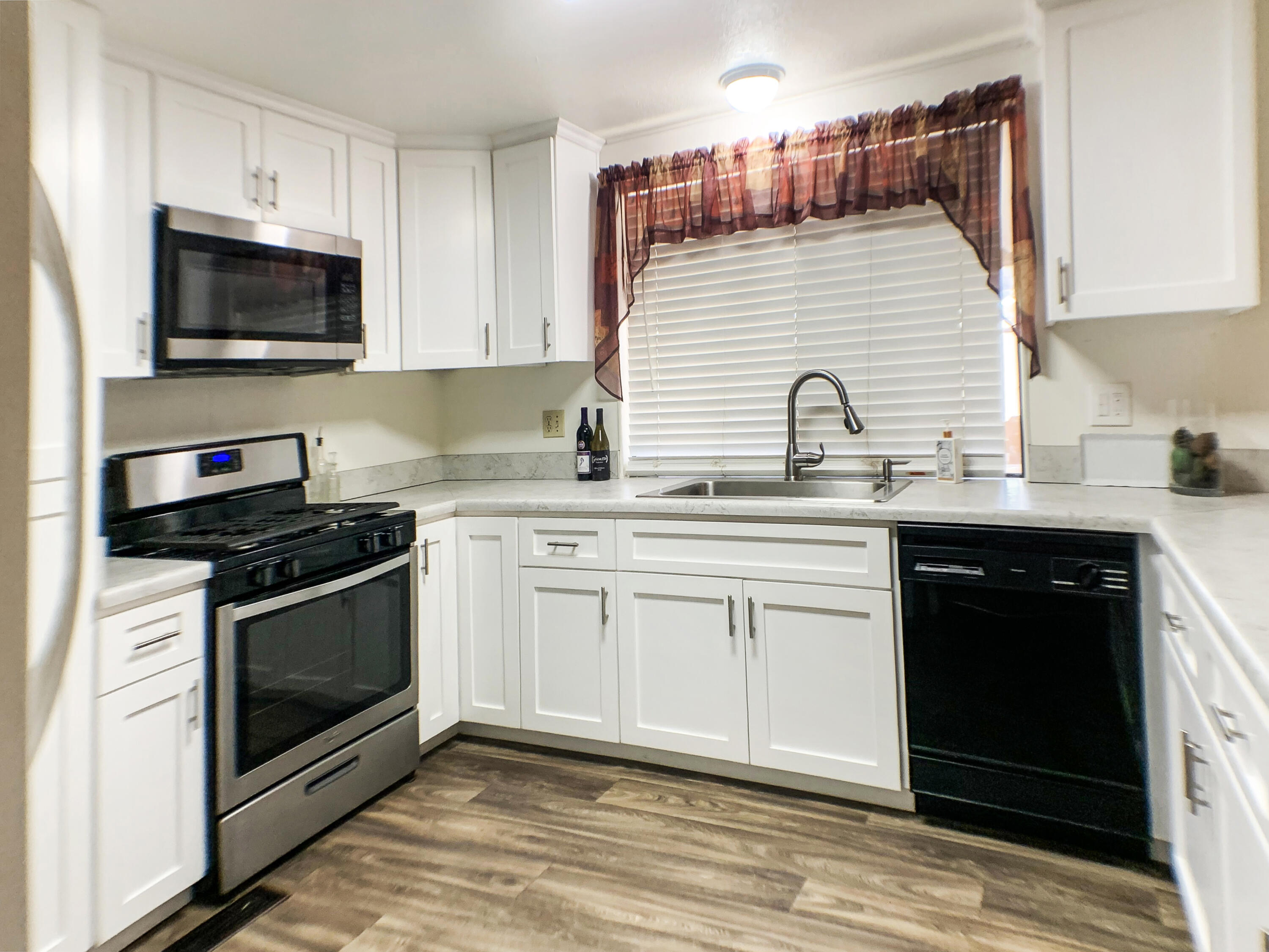 47685 Prado Way Indio, CA 92201 - Photo 11 of 26 a kitchen with stainless steel appliances granite countertop a sink a stove a microwave and wooden cabinets