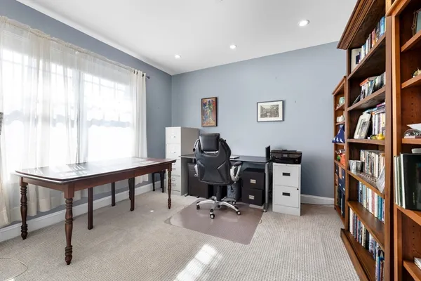 a view of a workspace with furniture and a window