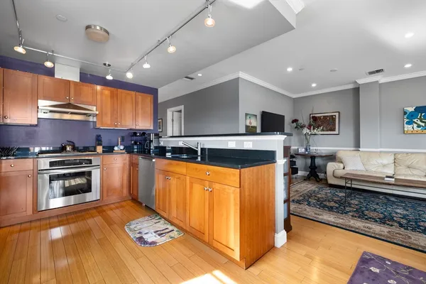 a kitchen with stainless steel appliances granite countertop a stove a sink and a microwave
