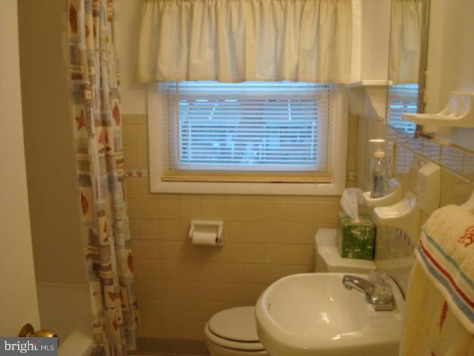 8013 Kimberly Road Dundalk, MD 21222 - Photo 12 of 12 a bathroom with a sink a toilet and shower curtain