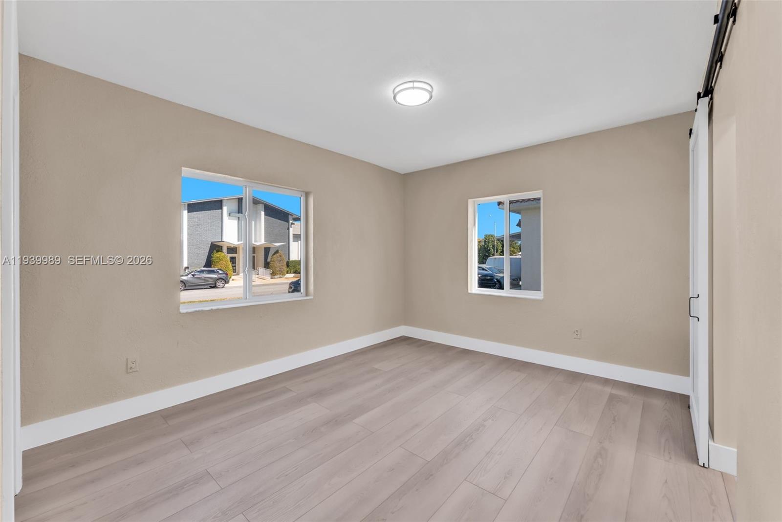 40 West 58th Street Hialeah, FL 33012 - Photo 14 of 25 a view of an empty room with window and wooden floor