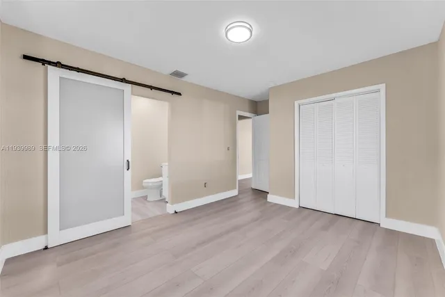 an empty room with wooden floor and a window