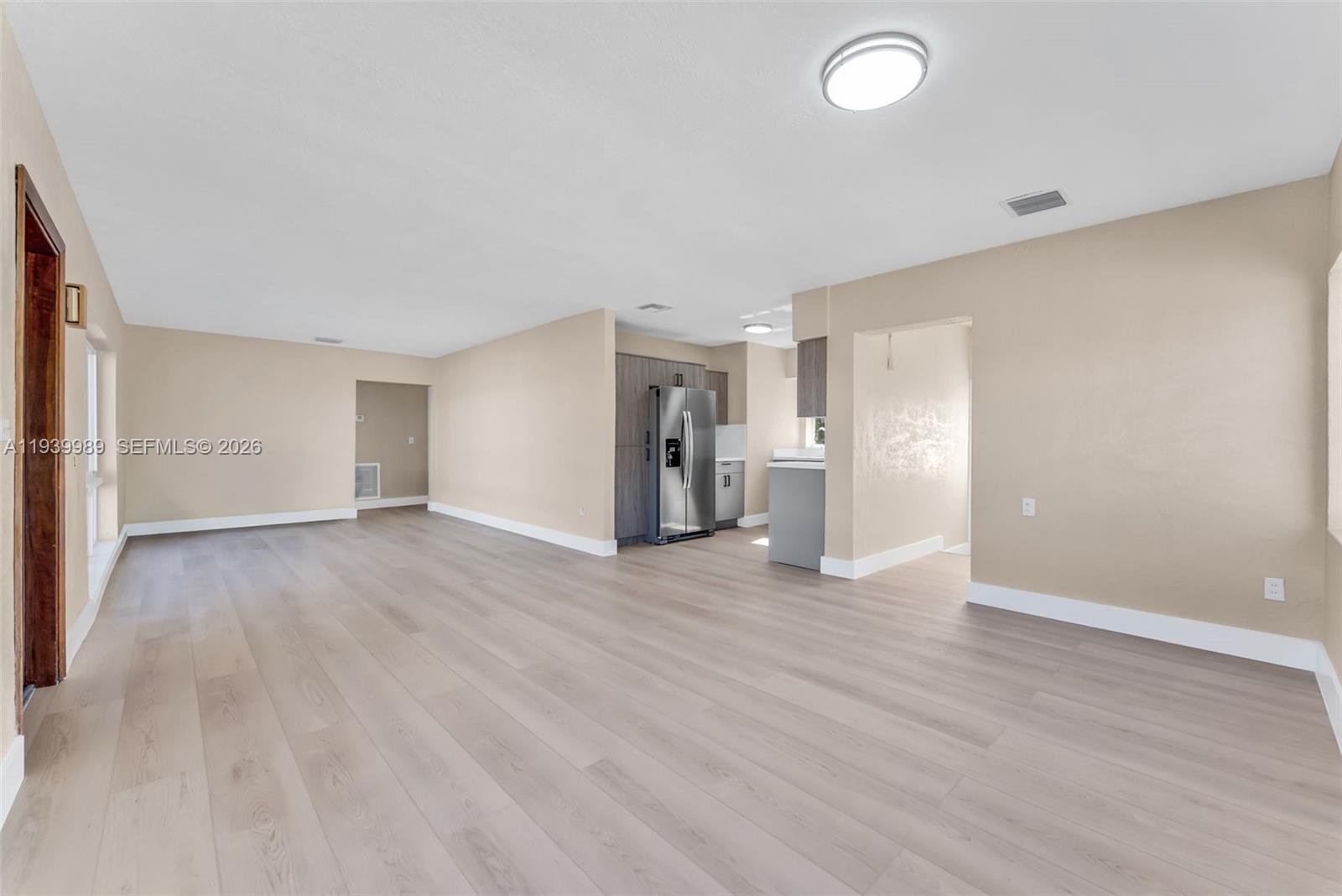 40 West 58th Street Hialeah, FL 33012 - Photo 6 of 25 a view of an empty room with wooden floor and a window