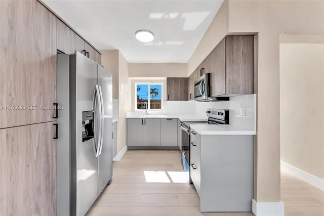 a kitchen with stainless steel appliances a refrigerator sink and cabinets