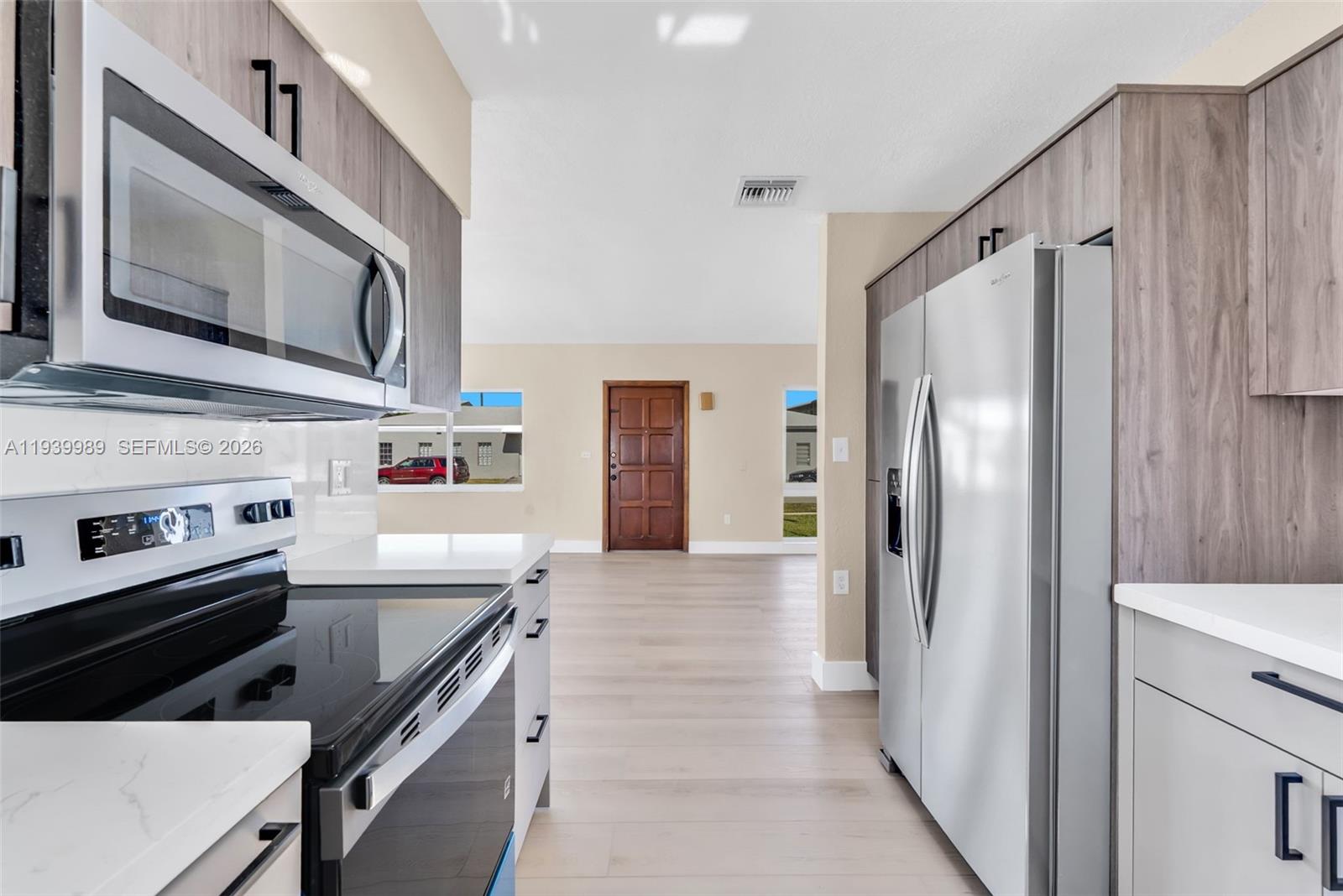 40 West 58th Street Hialeah, FL 33012 - Photo 8 of 25 a kitchen with stainless steel appliances a stove microwave and a refrigerator