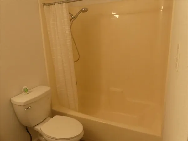 a white toilet sitting next to a white wall