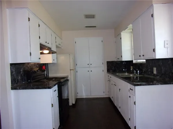 a kitchen with stainless steel appliances a sink a stove and a refrigerator