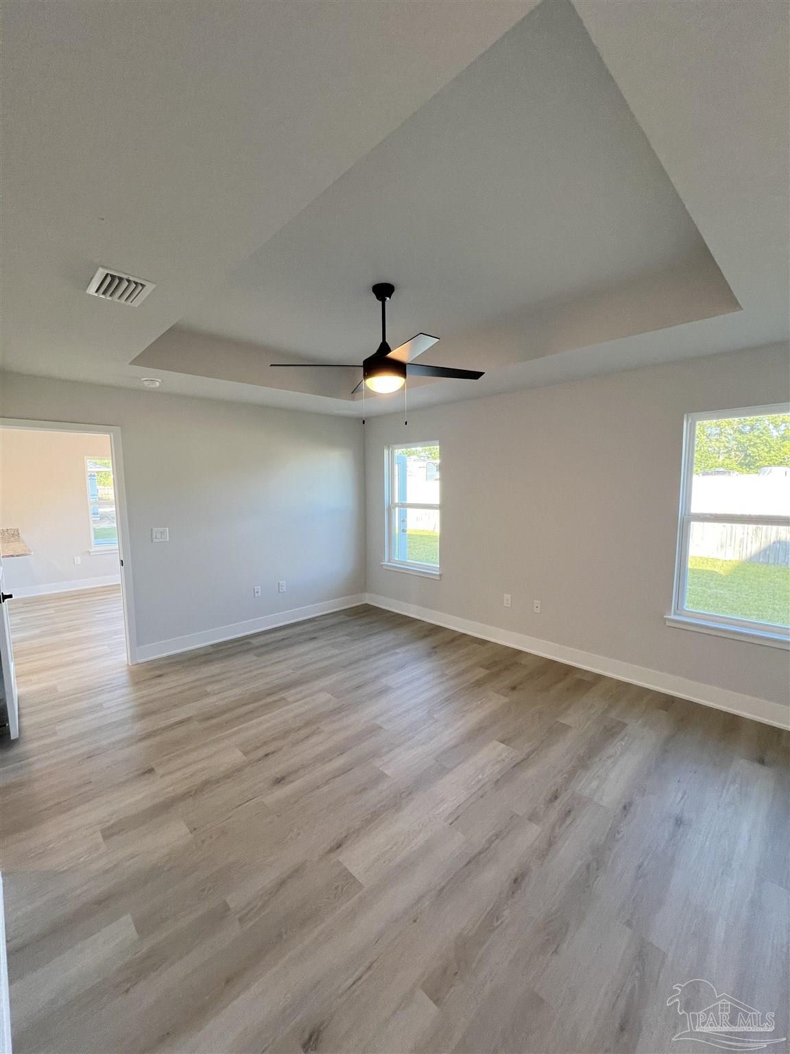 3327 Bliss Lane, Unit 12E Cantonment, FL 32533 - Photo 11 of 15 an empty room with wooden floor and windows