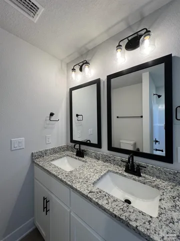 a bathroom with a granite countertop sink and a mirror