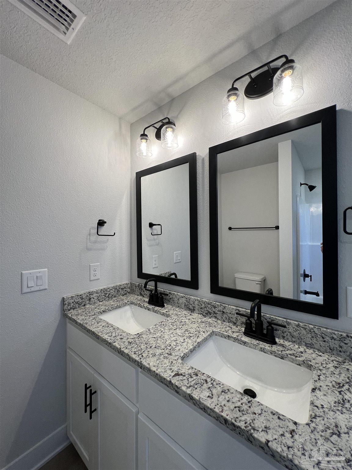 3327 Bliss Lane, Unit 12E Cantonment, FL 32533 - Photo 13 of 15 a bathroom with a granite countertop sink and a mirror